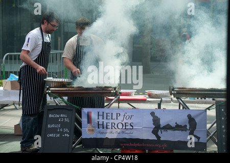 Männer kochen auf Rauchen Grillen bei der Hilfe für einen guten Zweck Helden stehen auf der Virgin London Marathon 2012 Stockfoto