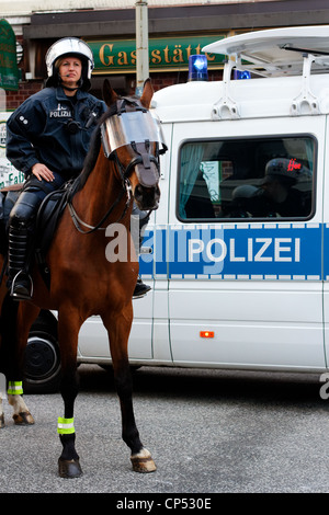 Deutsch montiert Polizistin vor ein Polizeifahrzeug in der Mai-Demonstration in Hamburg, Deutschland am 1. Mai 2012. Stockfoto