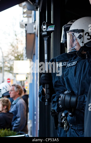 Deutsche Polizisten Film Mai-Demonstrationen von der Sicherheit der Ladentür in Hamburg, Deutschland am 1. Mai 2012. Stockfoto