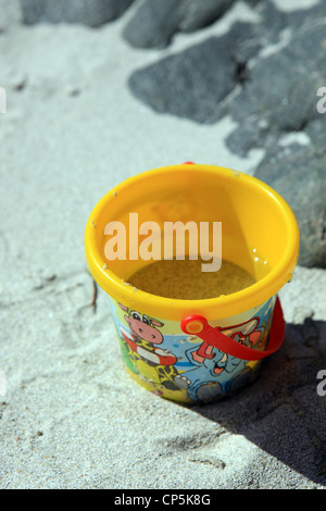Childs gelb Eimer an einem Sandstrand Stockfoto
