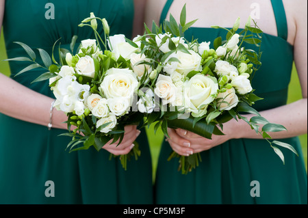 Brautjungfern in grünen Kleidern hält Strauß Rosen bei einer Hochzeit Stockfoto