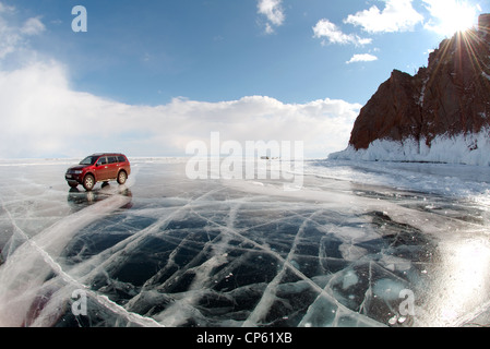 Red Offroader Fahren entlang der klaren Eis eines zugefrorenen See. Baikalsee, Insel Olchon, Sibirien, Russland Stockfoto