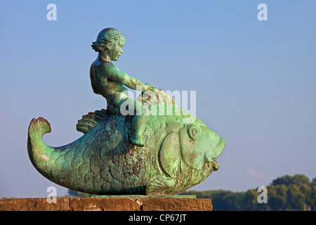 Die Skulptur Putto Auf Dem Fisch / Putto auf dem Fisch entlang der Maschsee, ein künstlicher See in Hannover, Niedersachsen, Deutschland Stockfoto