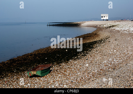 Kleine grüne Beiboot an der Schindel Küste Morecambe, Lancashire. Stockfoto