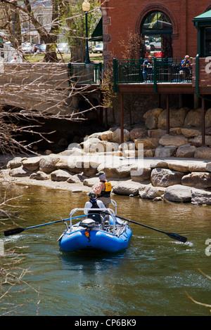 Schutzherren von Bootshaus Cantina Restaurant Watch von Außenterrasse als fliegen Fischer in einer geführten Boot schwimmt den Arkansas River Stockfoto