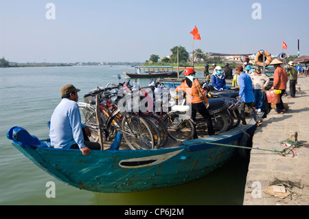 Horizontale Ansicht eines traditionellen Fähre laden Passagiere und Fahrzeuge onboard auf dem Thu Bồn Fluss im Zentrum von Hoi An, Vietnam. Stockfoto