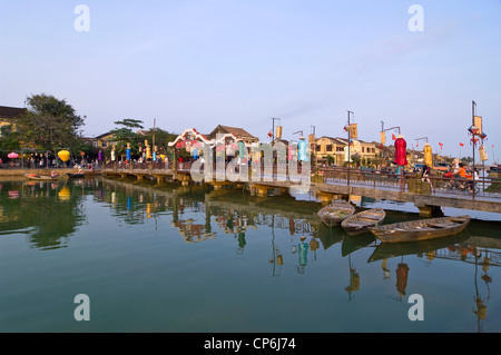 Horizontale Blick auf die Boote und die eingerichtete Thu Bồn River Bridge im Wasser im Zentrum von Hoi An Altstadt, Vietnam wider. Stockfoto