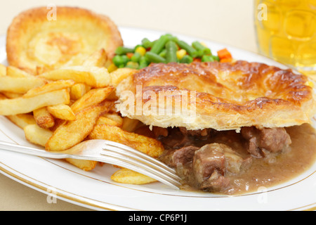 Eine Mahlzeit eine hausgemachte Steak und Kidney Pie mit französischer gebratene Kartoffelchips Yorkshire Pudding und Mischgemüse Stockfoto