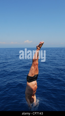 Ein junger Mann springt kopfüber ins Meer, Portoferraio, Italien Stockfoto