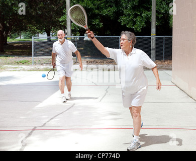 Aktive Senioren paar Squash auf einem öffentlichen Platz zu spielen. Stockfoto