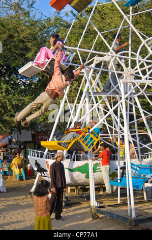 Ein Mann treibt ein motorloses Riesenrad vom Aufstieg auf den Gipfel, an der Kante hängen und nach unten springen, halten Sie auf. Bombay Indien Stockfoto