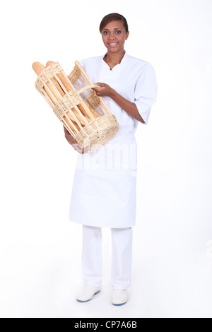 Brünette Frau mit einem Korb mit Brot Stockfoto