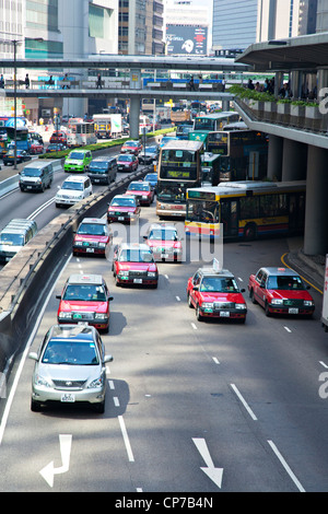 Taxis, Busse und andere Fahrzeuge auf den Straßen Hong Kongs am frühen Morgen Rush hour. Stockfoto