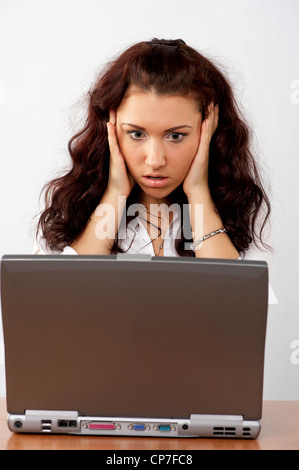 Porträt von schöne junge Geschäftsfrau an ihrem Schreibtisch, überrascht auf der Suche, um den Laptop-Bildschirm Stockfoto