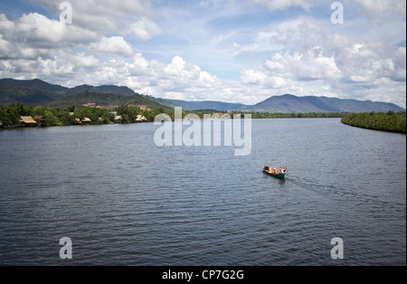 Ein Fischerboot, Reisen auf dem Fluss Kampot, mit den Bokor Bergen im Hintergrund. Stockfoto