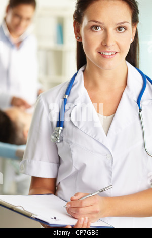 Hübsche Krankenschwester in uniform bereit hält ein Klemmbrett mit einem leeren Notizen Stockfoto