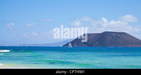 Norden von Fuerteventura, Blick nach Isla de Lobos, kleine weiße Yacht vor der Stockfoto