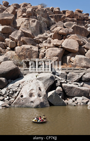 Indische Touristen in einem traditionellen runden Boot (Coracle). Tungabhadra Fluss. Hampi. Indien Stockfoto