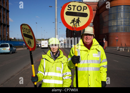 Schule Kreuzung Patrouille Offiziere Lollipop-Mann und Frau Glasgow Schottland, Vereinigtes Königreich Stockfoto