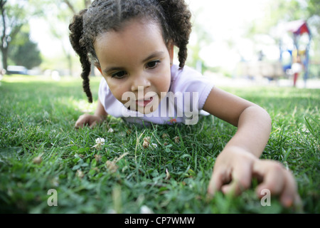 Junges Mädchen auf der Suche nach ein vierblättriges Kleeblatt in einem Park. Stockfoto