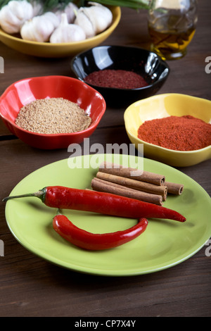 Platten mit Gewürzen auf einem alten Holztisch Stockfoto