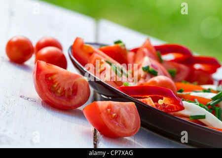 Gesunder Salat mit Tomaten im Garten Stockfoto