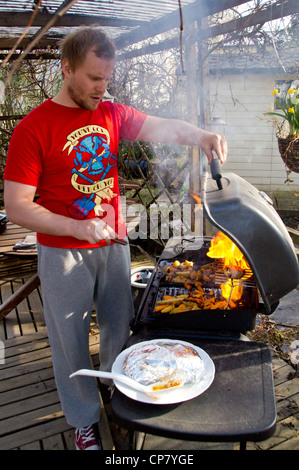 Mann Grillen Grill Essen. Grill-Sets in Flammen Stockfoto