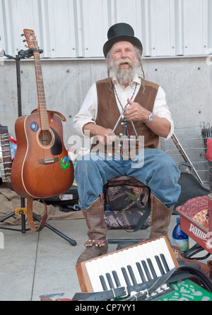 Ein Straßenmusikant spielt das Dreieck auf dem Bauernmarkt in Santa Fe, New Mexico. Stockfoto