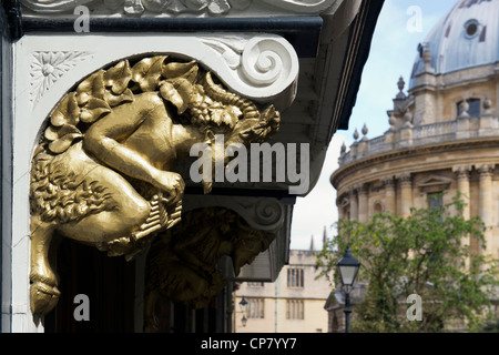 Faun Schnitzereien über dem aslan Tür in Brasenose College in St Mary's Passage mit Radcliffe Camera im Hintergrund. Oxford, Oxfordshire, England Stockfoto