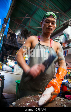 Skalierung von Fisch in Khlong Toey Markt in Bangkok, Thailand Stockfoto