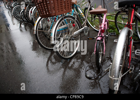 Fahrräder geparkt an einem regnerischen Tag in Tokio, Japan. Stockfoto