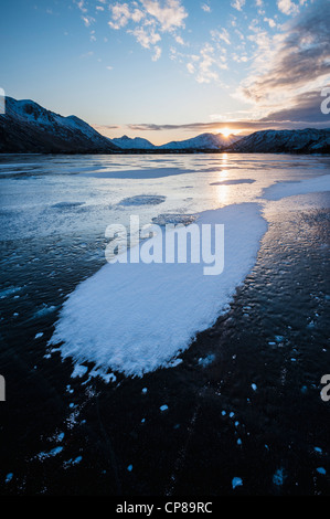 Winter-Sonnenaufgang am zugefrorenen See Urvatnet, Lofoten Inseln, Norwegen Stockfoto