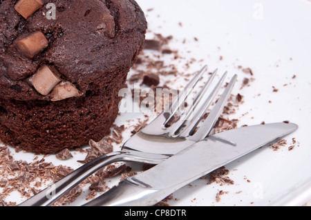 Braune Muffins mit Schokolade und Besteck auf dem Teller Stockfoto
