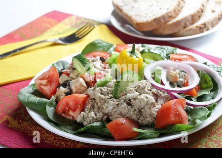 Ein Mittagessen Salatteller von Thunfisch und Feta-Käse-Salat mit Beilagen aus Tomaten, Gurken und Zwiebeln mit Vollkornbrot. Stockfoto