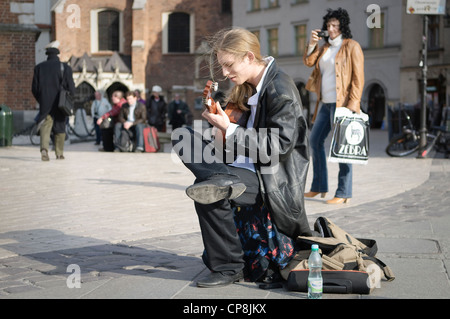 Eine männliche Straßenmusikant Gitarre auf dem Marktplatz, Krakau, Polen. Stockfoto