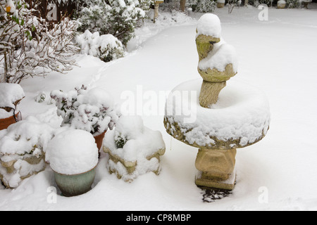 Schneebedeckte Vogeltränke im Garten Stockfoto