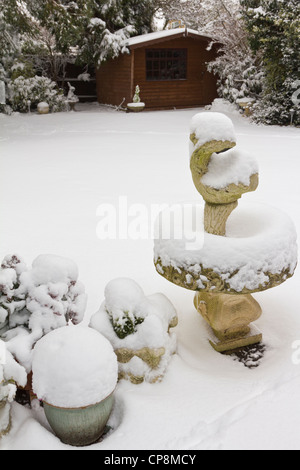 Schneebedeckte Vogeltränke im Garten Stockfoto