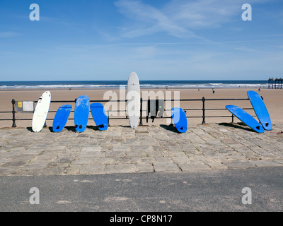 Surfbretter gebunden gegen Meer Handlauf außerhalb der Surfshop im Saltburn Cleveland UK Stockfoto