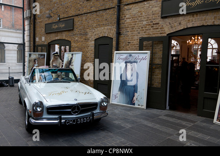 60er Jahre Mercedes-Benz SL verwendet als Requisit außerhalb der Traffic People Shop, Old Spitalfields Market, London, England, UK. Stockfoto