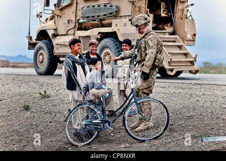 Ein Fallschirmjäger mit der 82. US-Luftlandedivision lehrt afghanischen jungen die Fistbump 22. April 2012 im Süden der Provinz Ghazni, Afghanistan zu tun. Der Soldat ist Teil einer Patrouille, die Sicherung der Highway 1, das Land der Hauptstraße zwischen Kabul und Kandahar. Stockfoto