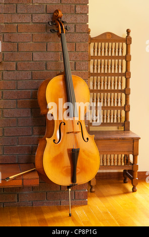 Violoncello oder Cello gegen einen Kamin Stockfoto