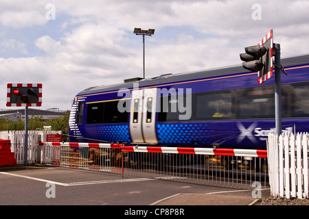 Eine s-Bahn vorbei an einem Bahnübergang nähert sich der Station in städtischen Dundee, Großbritannien Stockfoto