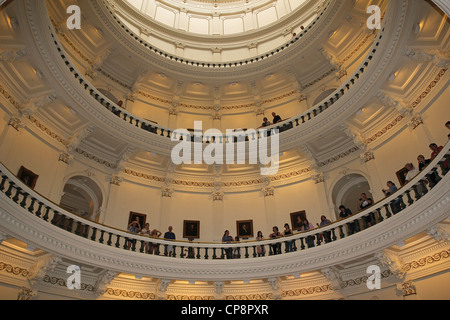 Menschen in den oberen Ebenen der Texas State Capitol Rotunde blicken einer Band-Performance auf der Eingangsebene. Stockfoto