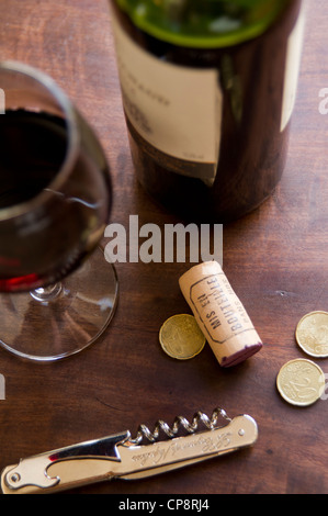 Glas Rotwein, Kork, Flasche und Opener auf einem Tisch in Paris, Frankreich Stockfoto