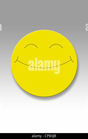 Gelbe Taste mit Smiley-Gesicht vor grauem Hintergrund Stockfoto