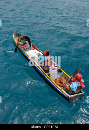 Frauen rudern Dugout in San Blas Inseln, Panama und den Verkauf von Souvenirs zu Besuch Yachten vor Anker, Artefakte, molas und die Flagge von Kuna Yala. Stockfoto