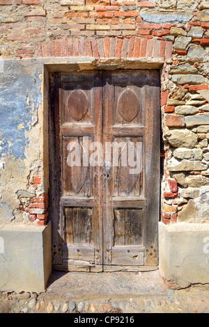 Vertikal ausgerichtete Bild der alten Holztür in Backstein-Haus in der Stadt von La Morra, Norditalien. Stockfoto