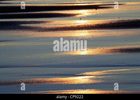 Am frühen Morgen niedrigen Sonnenlicht reflektiert den nassen Sand, Bamburgh, Northumberland, England, UK Stockfoto