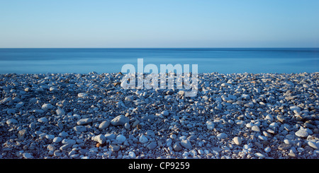 Blick aus Meer von einem Kieselstrand in der blauen Farbton von Twilight, Penmon, Anglesey, Wales, UK Stockfoto