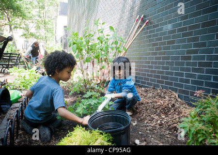 Freiwillige Blumen Pflanzen und eine allgemeine Aufräumen von Spielplatz im Stadtteil Chelsea in New York Stockfoto